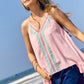 Woman in blush tank top and jean shorts